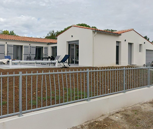 Maison moderne blanche avec toit en tuiles, terrasse, et clôture grise devant à Rochefort en Charente-Maritime 17