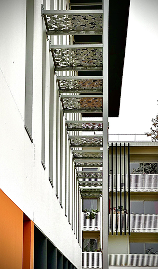 Façade de bâtiment moderne avec brise-soleil à motifs et balcons à rambardes blanches à Rochefort en Charente-Maritime 17